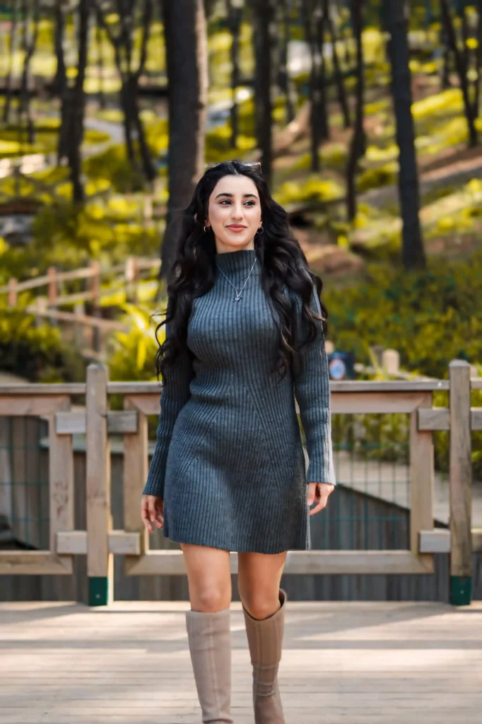 Woman wearing a gray ribbed sweater dress with tall beige boots
