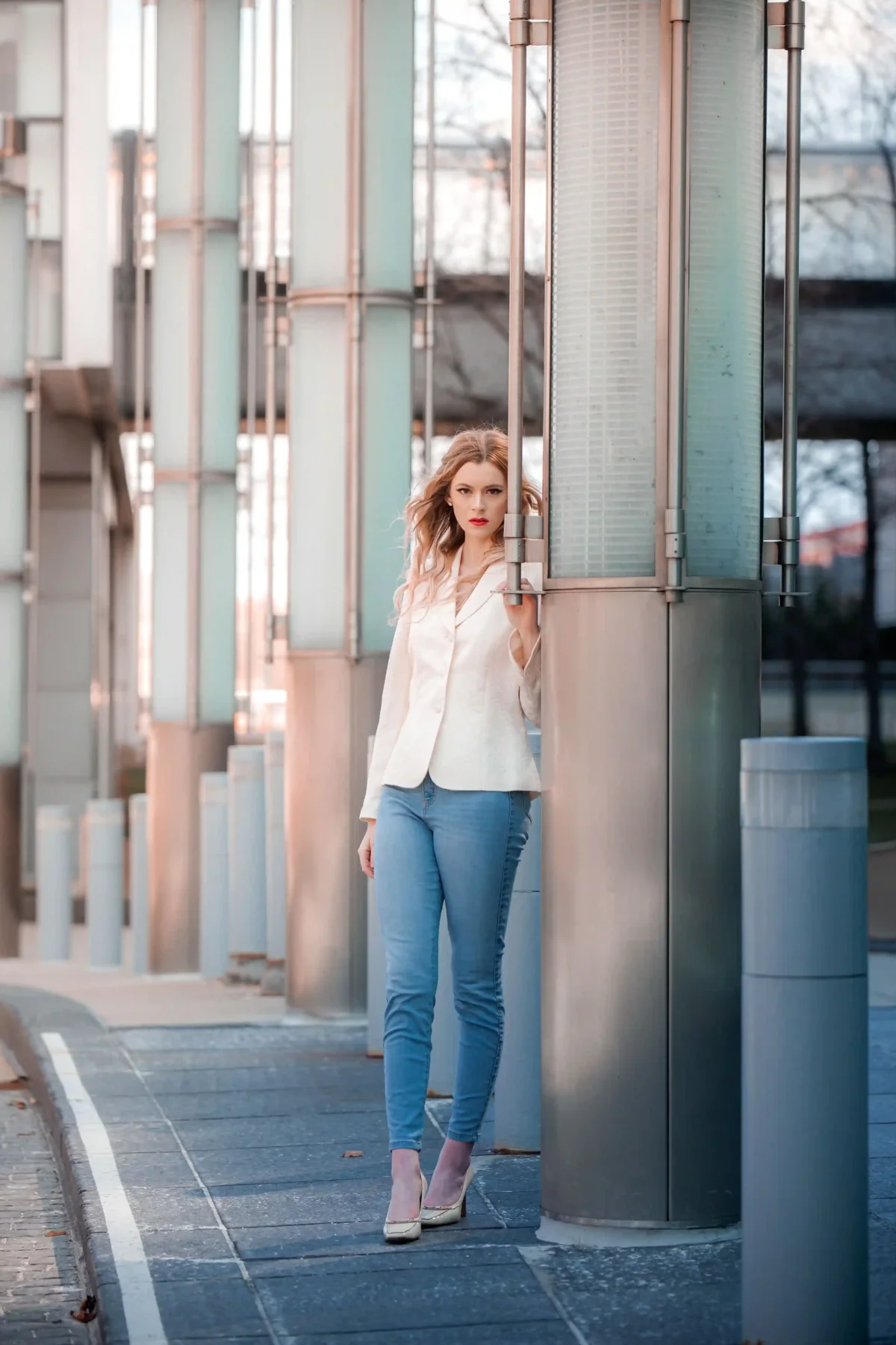Woman wearing a white blazer with blue skinny jeans and pointed heels