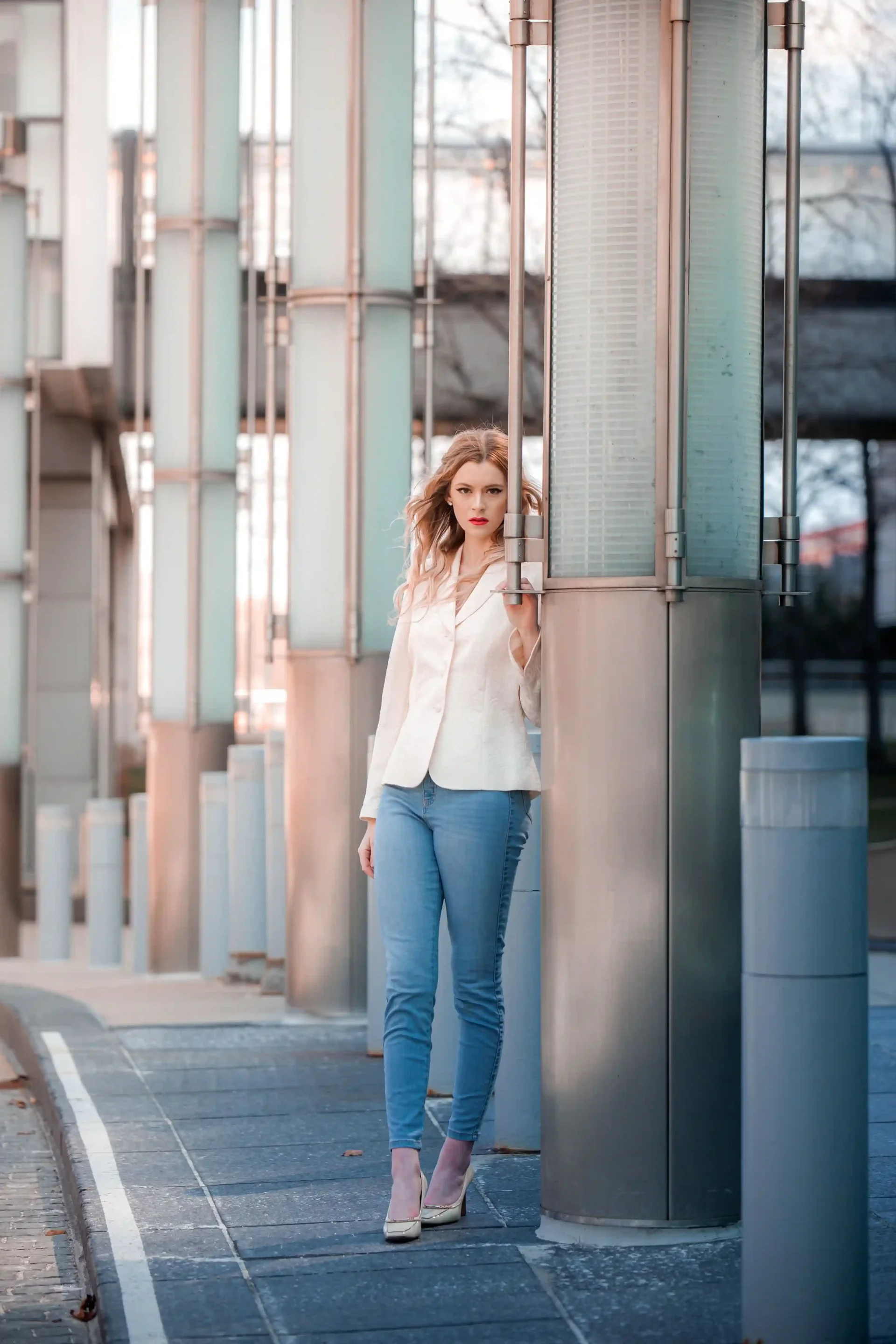 Woman wearing a white blazer with blue skinny jeans and pointed heels